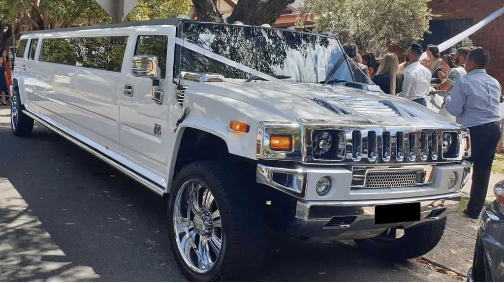 White Hummer H2 wedding limo with wedding ribbons on bonnet